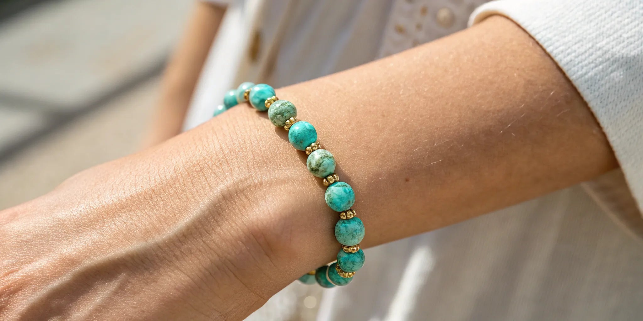 Adjustable turquoise gemstone bracelet with gold accents worn on a wrist.