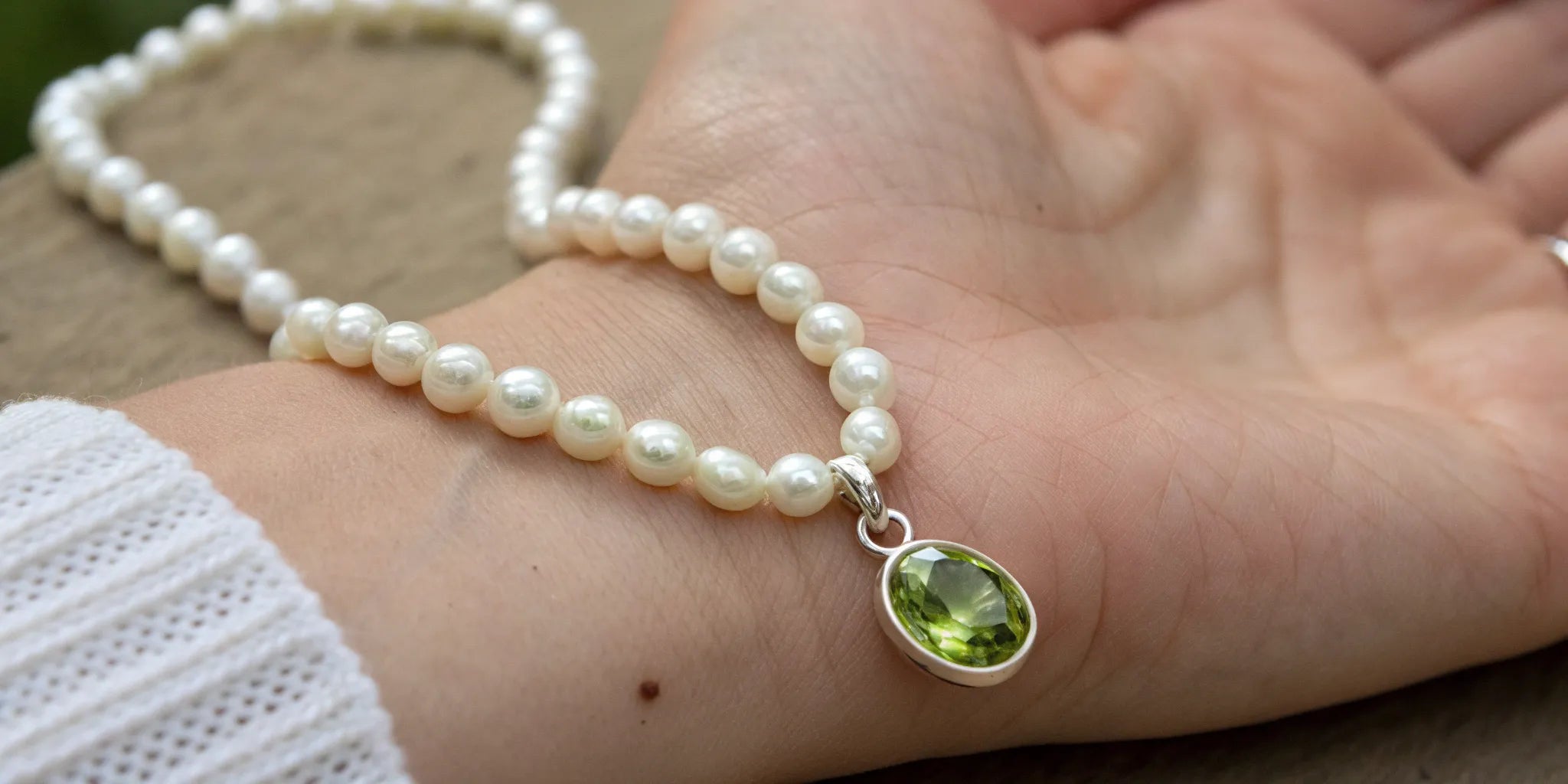 Elegant peridot and pearl necklace featuring a vibrant green peridot pendant.